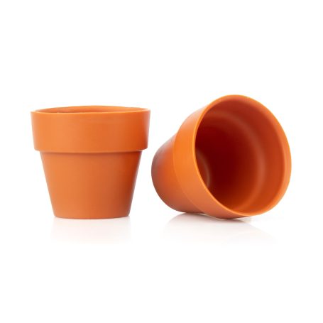 Zwei große, leere Terrakotta-Blumentöpfe aus Schokolade, einer stehend, einer umgekippt.