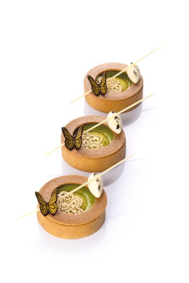 Schmetterlingsdekor in gold / zartbitter auf einem Tartelette angerichtet.