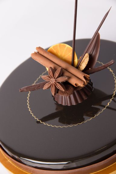 Verschiedene Gewürz-Schokoladendekore auf einem Dessert angerichtet.